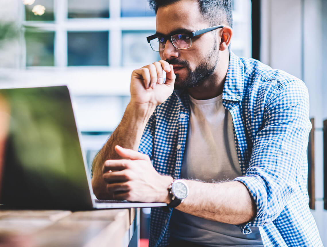 Man-with-glasses-working-on-laptop