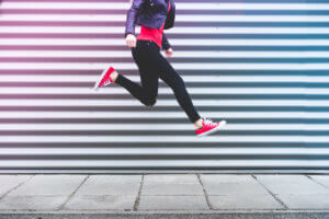 young-happy-woman-jumping-in-front-of-metal-wall-picjumbo-com